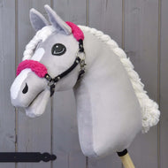 Zwart halster met rozenbont - kunstleer van Hobby Horse LarDen met lichtgrijze pluche kop, accenten van rozenbont, witte manen van garen en zwart halster op een houten stok, tegen een achtergrond van houten planken