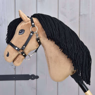 Hobby Horse Samantha met zwart halster van Hobby Horse LarDen met een lichtbruin gezicht, zwarte manen van garen, gestikte details en een zwart halster, gepresenteerd tegen een lichte houten achtergrond.