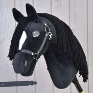 Hobby Horse Cloony met zwart halster van Hobby Horse LarDen, een pluchen American Quarter Horse-hengst met zwarte stof, een witte aftekening op het gezicht, knoopogen, zwarte manen van garen en hoofdstel op een lichte houten achtergrond.