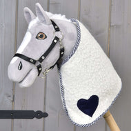 Deken cube blauw van Hobby Horse LarDen op een pluchen Hobby Horse met een grijs gezicht, zwart hoofdstel en een deken met blauwe accenten, gemonteerd op een houten stok tegen een houten achtergrond.