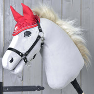 Oornetje gehaakt Rood Sport van Hobby Horse LarDen op een pluchen Hobby Horse met wit gezicht, zwart hoofdstel en blonde manen, voor een lichte houten wand.