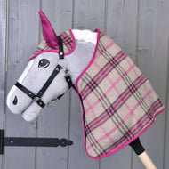 Set Kubus Roze van Hobby Horse LarDen op een gevulde Hobby Horse met grijze kop, zwart hoofdstel en geruite deken in beige, roze en zwart, getoond tegen een houten wand.