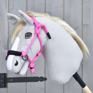 The Hobby Horse LarDen Rope Halter Pink, shown on a plush hobby horse with light gray fabric, white mane, and white face stripe, is an adorable accessory featured against a wooden background.