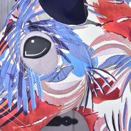 Close-up van het Hobby Horse Beschermpak Blauw Jungle (Lycra) van Hobby Horse LarDen met een kleurrijk abstract dierendesign, een groot grijs oog en golvende patronen. De wasbare hoes heeft een licht onscherpe grijze achtergrond, perfect voor Hobby Horse-liefhebbers.