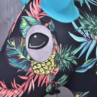 Close-up van het Hobby Horse Beschermpak Ananas (Lycra) van Hobby Horse LarDen, met een kleurrijk tropisch patroon met bladeren, gele ananassen en een groot cartoonachtig grijs oog, perfect voor trendy Hobby Horse-liefhebbers.