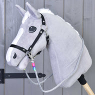 Teugels Manhattan van Hobby Horse LarDen met een grijze Hobby Horse met witte manen, zwart halster, handgemaakte teugels en een houten stok, getoond tegen een grijze houten wand.