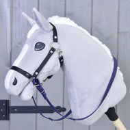 Teugels gerubberd Donker paars van Hobby Horse LarDen op een grijs pluchen Hobby Horse met zwart hoofdstel, witte manen en een houten stok, getoond voor een lichtgrijze houten achtergrond.