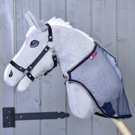 Een grijze pluche Hobby Horse LarDen met zwart hoofdstel en de Vliegendeken LarDen bevestigd, getoond tegen een lichtgrijze houten deur met een zwart scharnier.