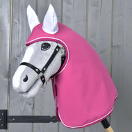 Regenjas Larden van Hobby Horse LarDen op een grijze Hobby Horse met een zwart hoofdstel en roze capuchon voor weerbescherming, getoond voor een houten wand.