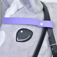 Close-up van het hoofd van een pluchen speelgoed van Hobby Horse LarDen, met het Compleet hoofdstel zonder neusriem Licht Paars, met een paarse band met hexagonaal patroon, metalen knop en afneembare teugels over grijze en witte vacht.