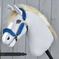 Bont halster Teddy Petrol van Hobby Horse LarDen op een pluchen hobby horse met lichtgrijze stof, witte snuit, blonde manen en een blauw halster van kunstleer op een zwarte stok, voor een houten achtergrond.