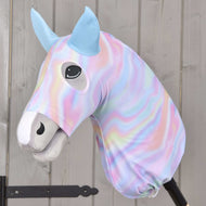 Hobby Horse Beschermpak Regenboog (Lycra) van Hobby Horse LarDen met een pluchen hoes in pastelkleurige regenboogkleuren, blauwe oren, een glimlachend gezicht en knoopoogjes, gemonteerd op een stok tegen licht hout.