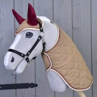 The Set Roma by Hobby Horse LarDen is a plush hobby horse with a light gray face, black bridle, tan quilted coat, and maroon ear bonnet—ideal for imaginative play or pairing with a blanket set.