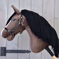 Hobby Horse Sisi met zwart halster van Hobby Horse LarDen, met een bruin pluchen lichaam, witte streep en zwarte manen van garen op een houten stok, ideaal als droom van een Hannoveraans sportpaard of prestatiemerrie.