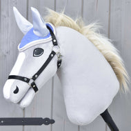 Oornetje Licht Violet van Hobby Horse LarDen op een pluchen Hobby Horse met een lichtgrijs lichaam, witte manen en zwart hoofdstel, tegen een houten achtergrond.