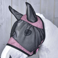 Een wit paard draagt het Hobby Horse LarDen Fly Mask De Luxe Pink, een wasbaar zwart-roze mesh masker dat de oren en het gezicht bedekt, voor een lichtgrijze houten achtergrond.