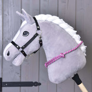 Cordéo roze streep van Hobby Horse LarDen, met een grijze pluchen paardenkop met witte manen, zwart hoofdstel en roze-witte cordeo op een houten stok, is ideaal om bitloos rijden te oefenen tegen een grijze houten wand.
