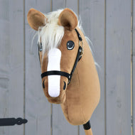 Hobby Horse Star met zwart halster van Hobby Horse LarDen, met een karamelkleurige vacht, witte bles, crèmekleurige manen en geleverd met een zwart halster, getoond tegen een grijze houten achtergrond.