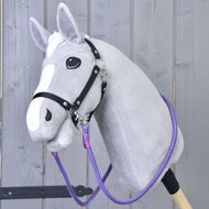 Teugels Viola van Hobby Horse LarDen op een grijze Hobby Horse met witte bles, zwart hoofdstel en opvallende handgemaakte teugels, met een pluchen kop op een stevige stok en getoond tegen een licht houten hek.