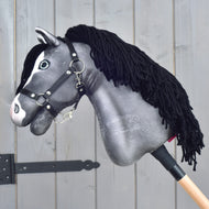 Hobby Horse Clover in side view, showing the grey plush head, black mane and black halter
