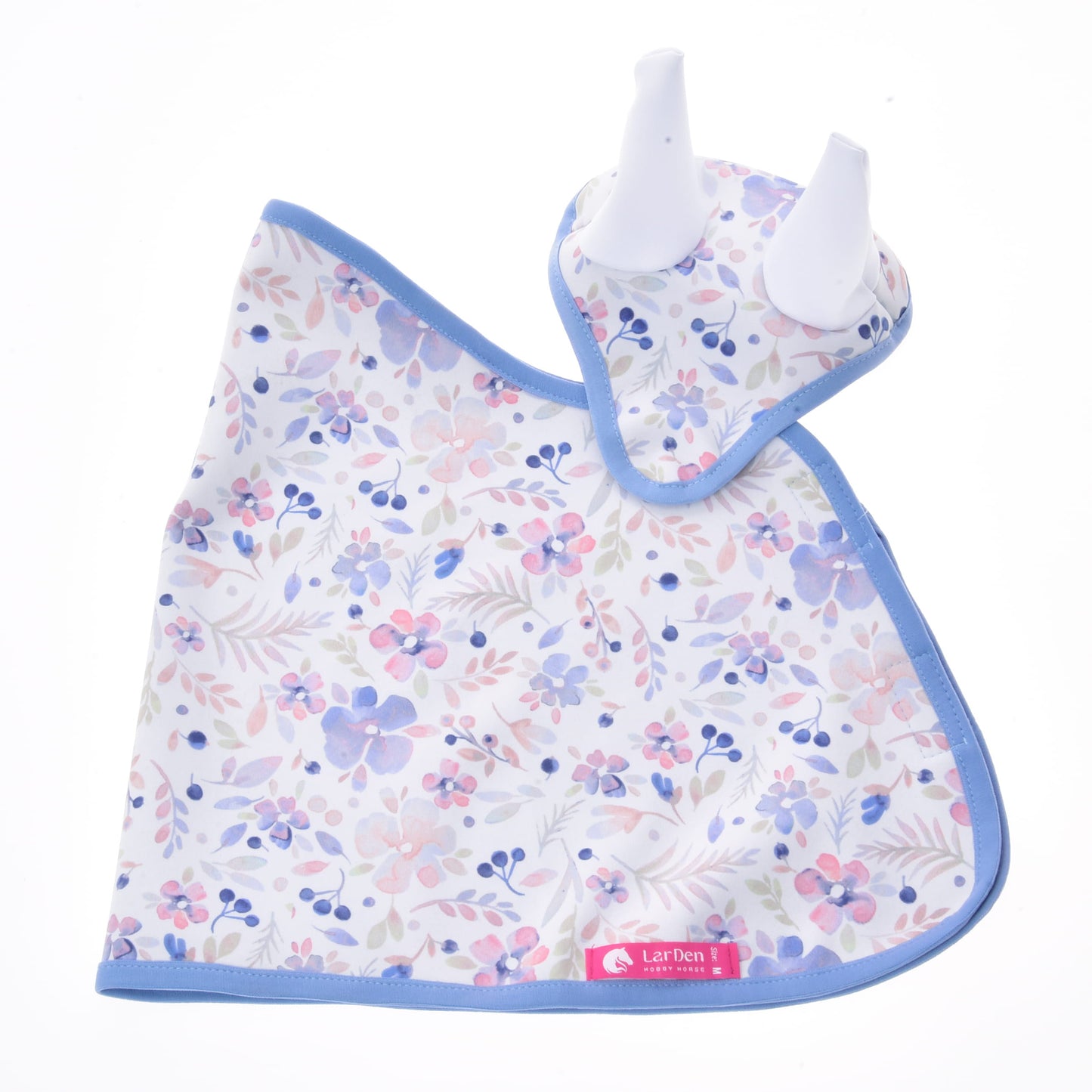 Set Vanessa NEW van Hobby Horse LarDen met een babyslab en bijpassende bijtring met blauwe bies, beide met een roze, paars en blauw bloemenpatroon op wit. De bijtring heeft twee witte siliconen uiteinden in de vorm van oren, wat het een charmante babyset maakt.