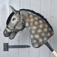Close-up in profiel van Hobby Horse Stormy met zwart halster van Hobby Horse LarDen, met de hand geairbrushte appelgrijze aftekeningen op de hals, zwarte manen en zwart halster.