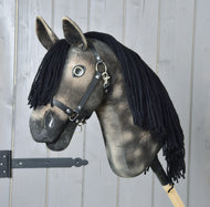 Hobby Horse Stormy met zwart halster van Hobby Horse LarDen, een appelgrijze Hobby Horse uit de Art Collection met donkere snuit, zwarte voorpluk en zwart halster, gemonteerd op een houten stok.