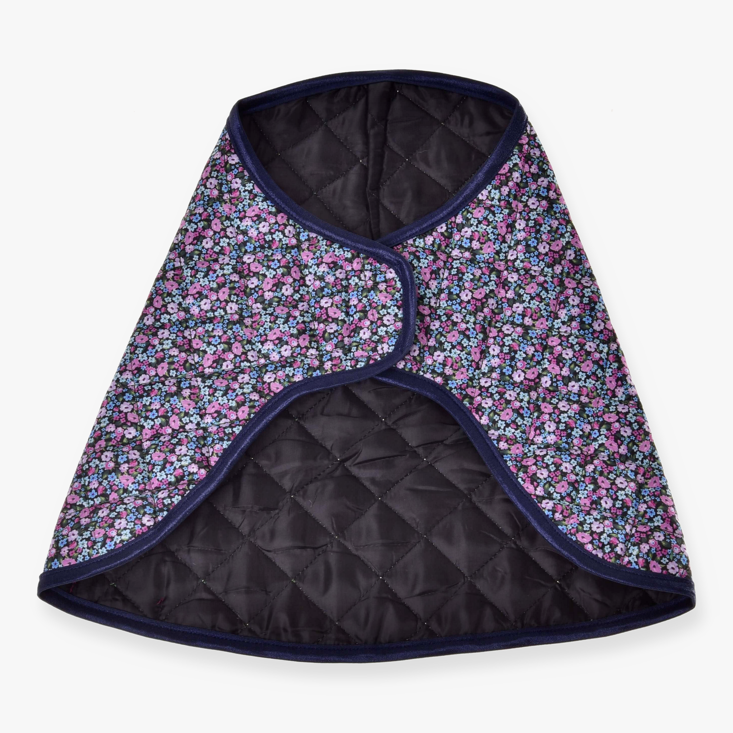 Deken Flower van Hobby Horse LarDen, een gewatteerd kledingstuk in capestijl met zwarte voering, een donker bloemenpatroon van kleine blauwe en paarse bloemen en donkerblauwe afwerking, dat doet denken aan een knusse paardendeken.