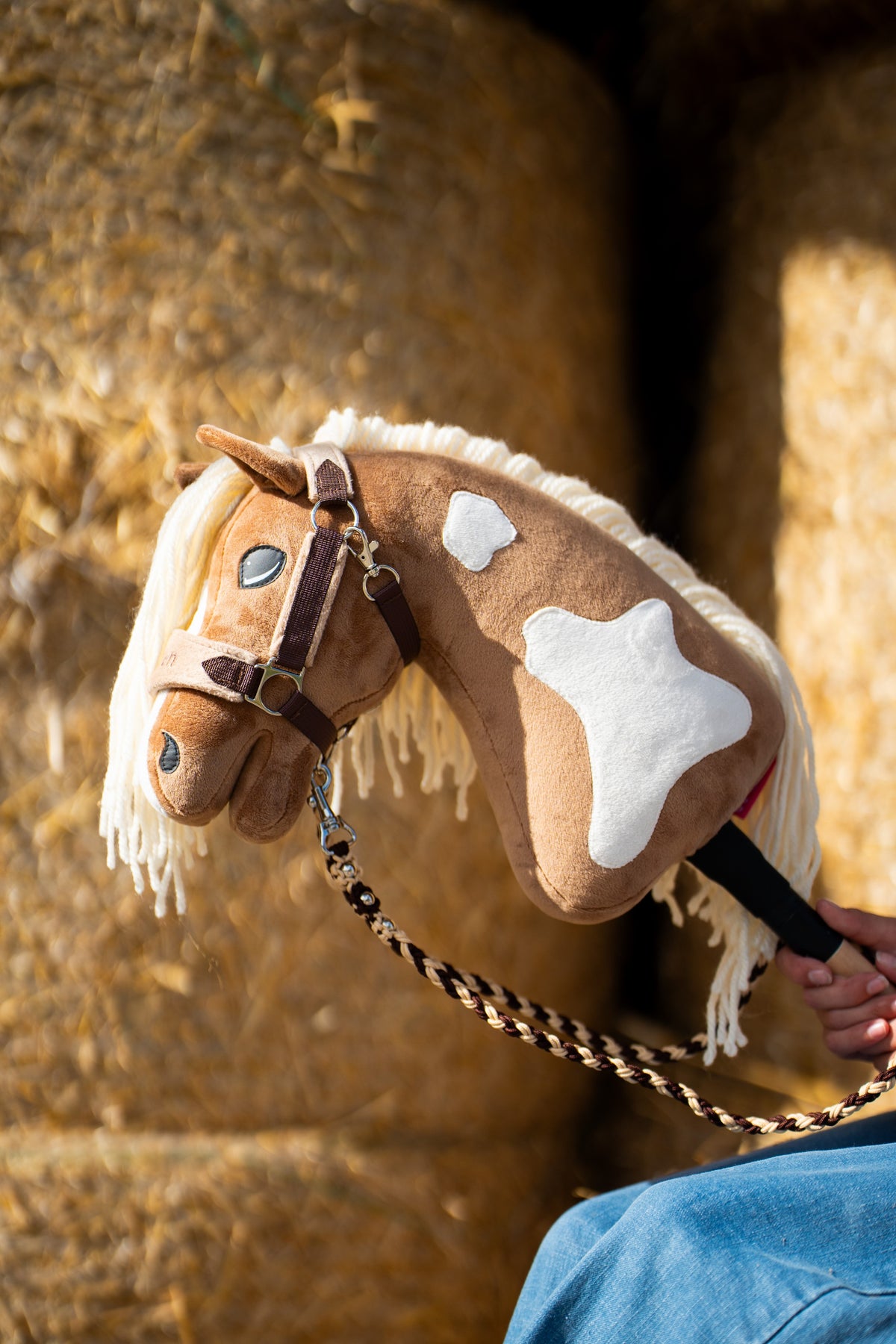 Detailfoto: de kop en hals van de Hobby Horse Fury met zwart Halster van Hobby Horse LarDen voor ronde strobalen - palomino pluche met witte aftekeningen, crèmekleurige garenmane - hier getoond met het met bont gevoerde LarDen Brown Halster en het gevlochten Bloom Brown Halstertouw
