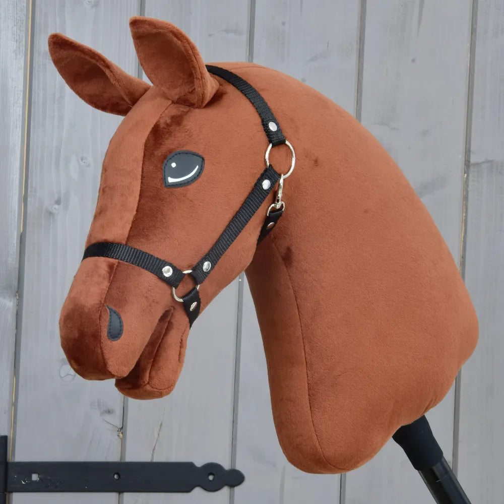 Experience imaginative play with the “Build your horse” hobby horse by related_to_12441055625556, featuring a plush dark chestnut head with blaze markings, a black bridle, and an attached stick—beautifully presented against a light wooden background for the perfect custom hobby horse adventure.