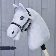 Bouw je paard, lichtgrijze pluchen Hobby Horse-kop op een houten stok met zwart hoofdstel, voor een grijze houten muur, ideaal voor iedereen die interesse heeft in het product “Bouw je paard” van related_to_12441055625556 of voor het personaliseren van je eigen Hobby Horse ter inspiratie van fantasierijk spel.