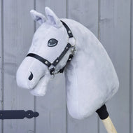 Bouw je paard, aangepast lichtgrijs pluchen Hobby Horse met opvallende turquoise ogen en zwarte teugels, gemonteerd op een houten stok en weergegeven voor een wand van verticale houten panelen.